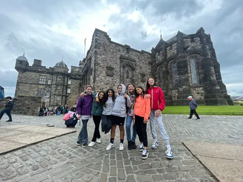 Group of female students in front of a historic stone building in Edinburgh