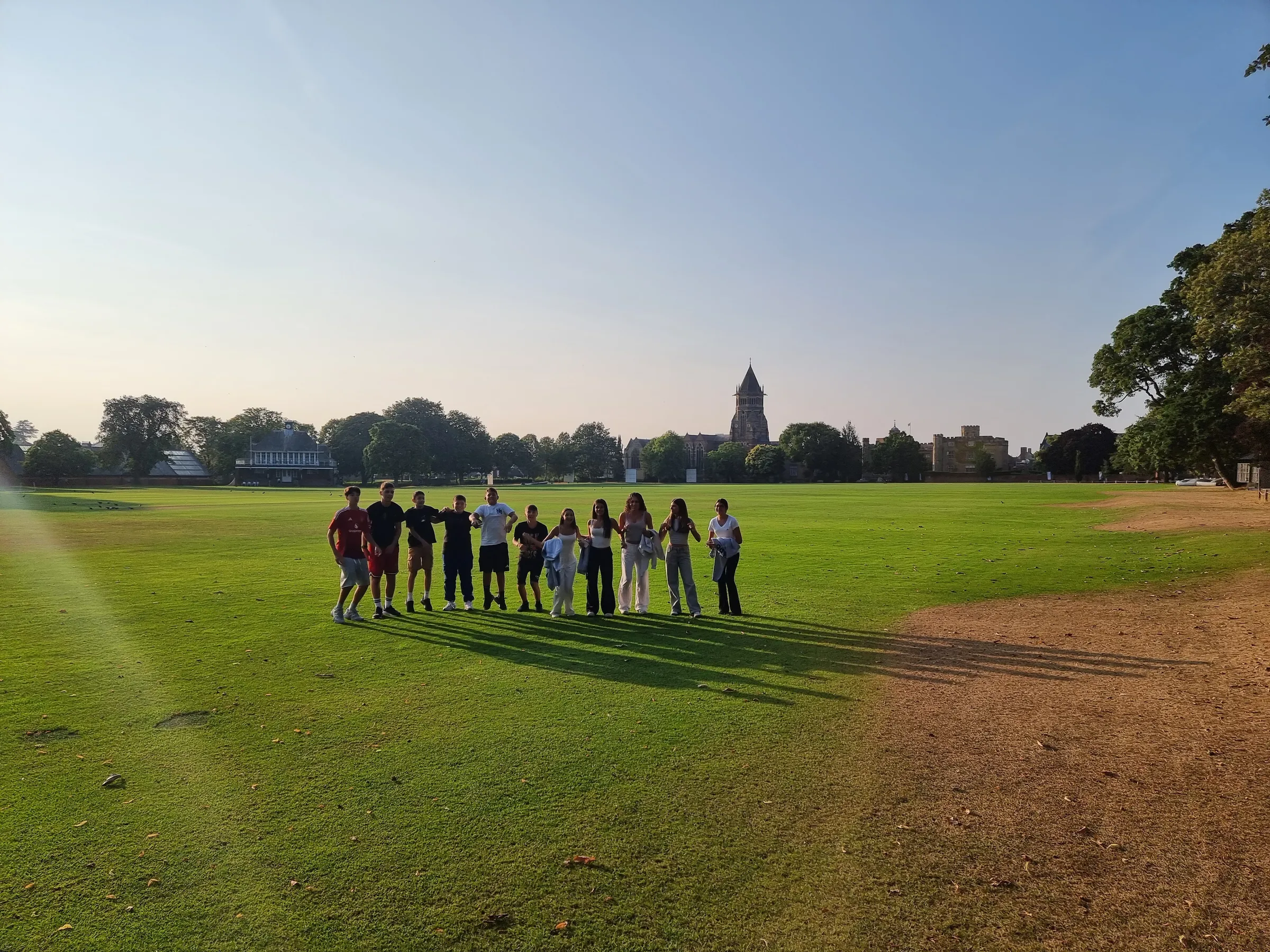 Rugby School sahasında Imagine1world öğrencileri, arka planda şapel kulesi