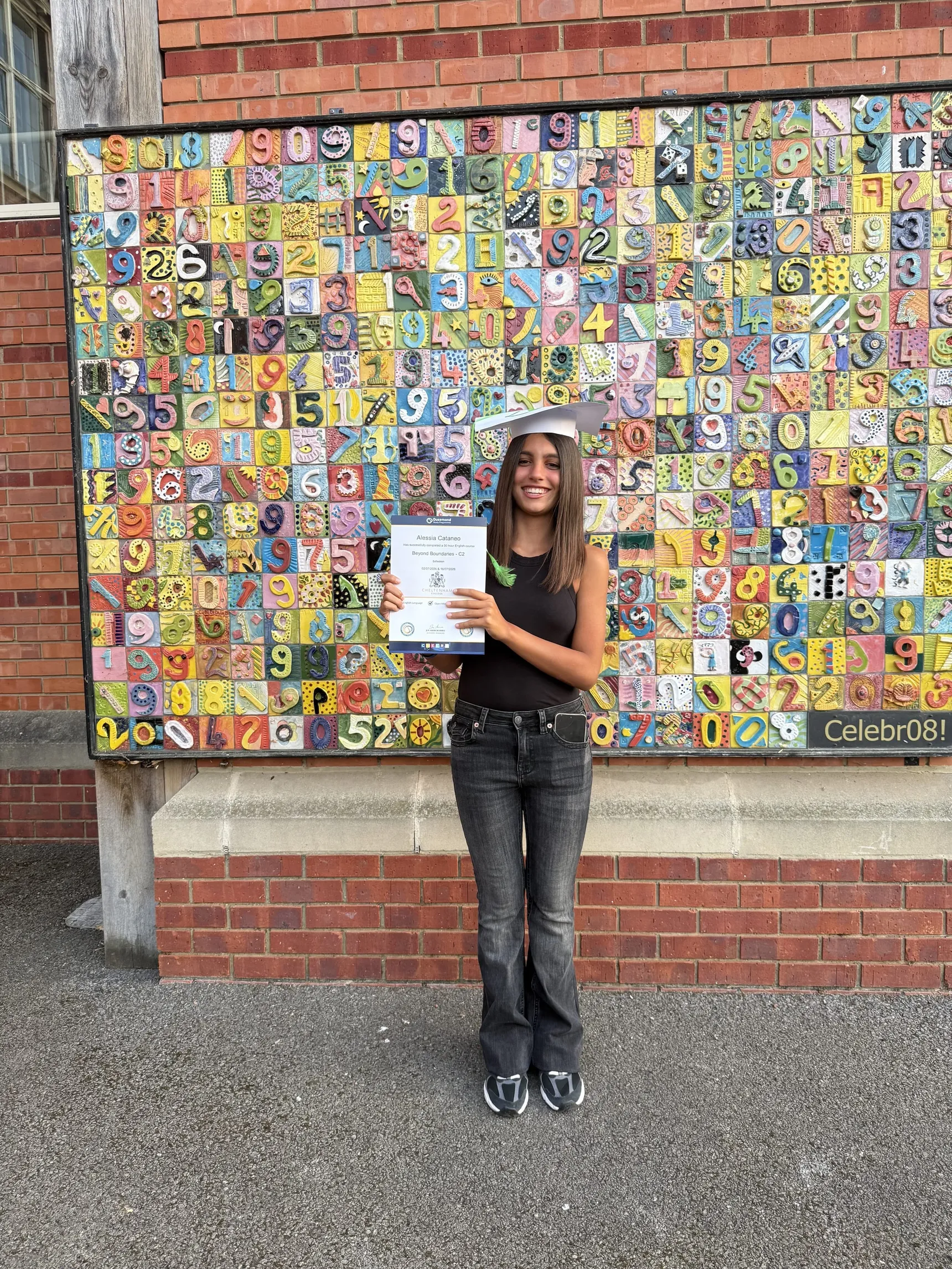 Student in front of a colourful mosaic